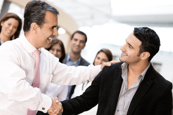 Two men happily shaking hands as if in agreeance on an idea