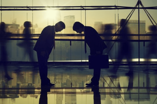 two business men bowing to one another