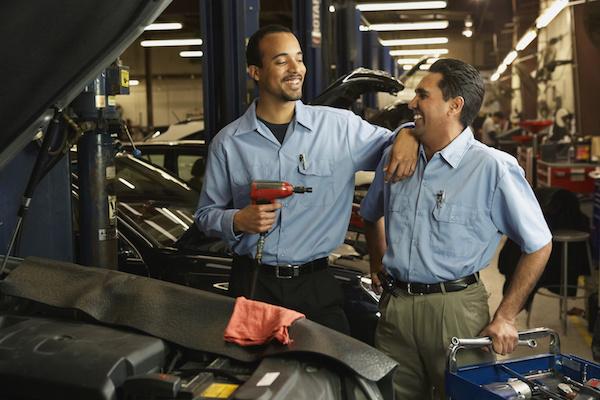 two mechanics smiling and laughing