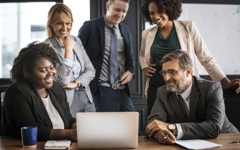 Diverse group of professionals looking with joy at a laptop screen