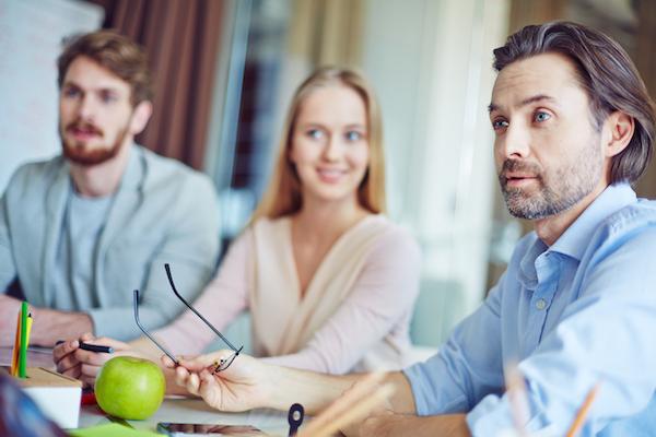 man looks startled while others smile about what they see