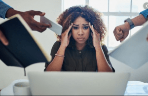 woman frowning and holding her head while two people on each side seem to be overwhelming her