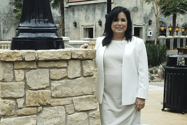 Judy Ryan posing at a conference center in business suit