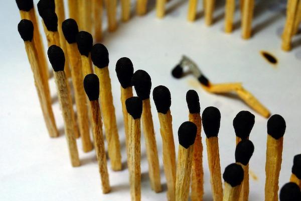 circle of burnt matches with one laying down in the center