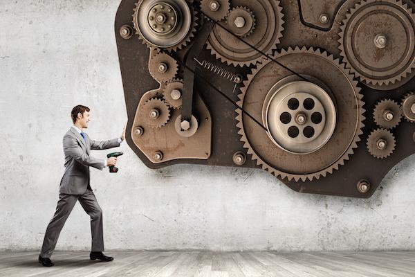 business man drilling on a big group of gears