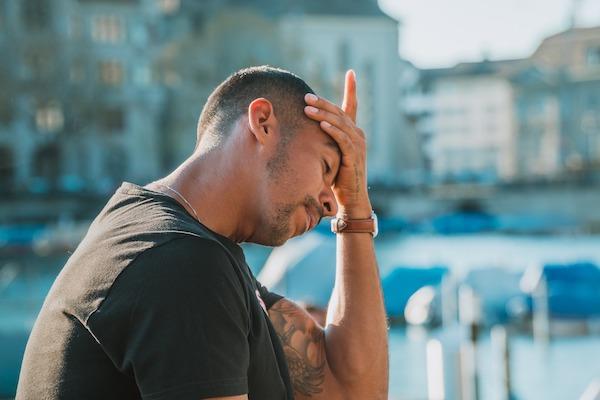 Frustrated man sitting outside