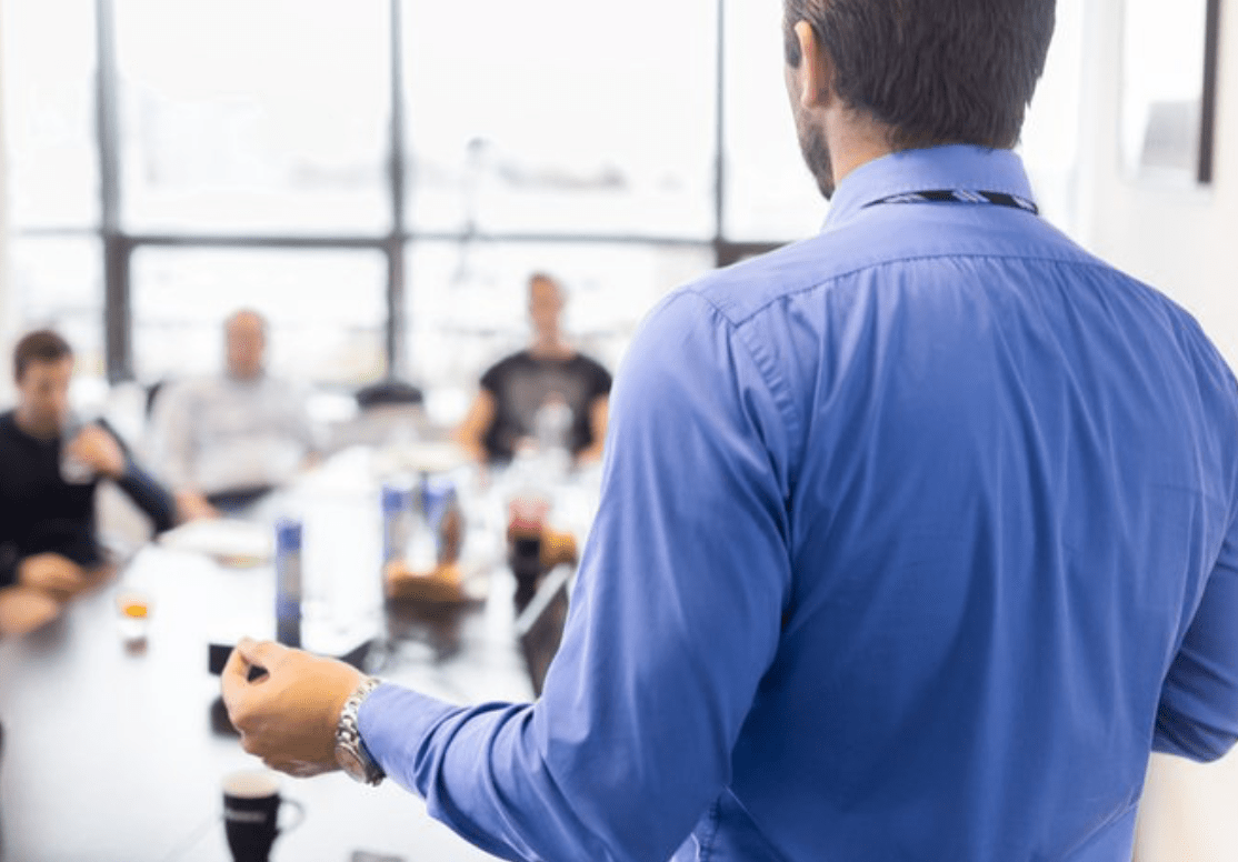 professional man presenting to group around conference table