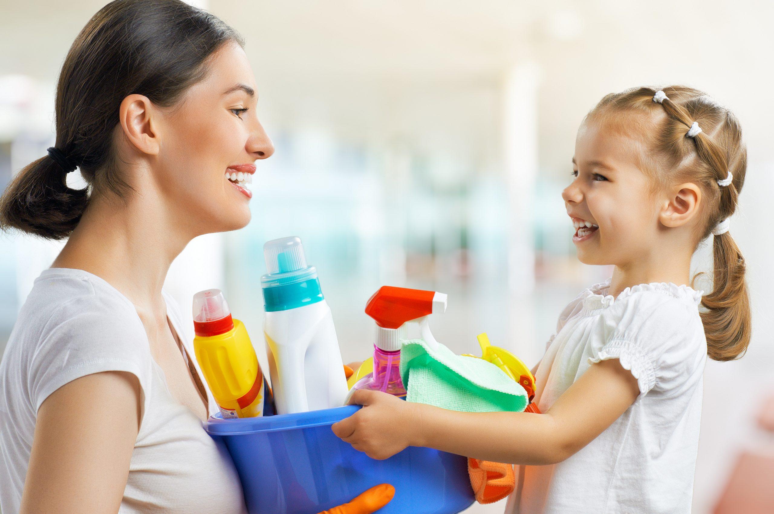 mom and small girl doing chores together and smiling
