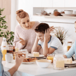 Mom yelling at son at dinner table with dad and sister
