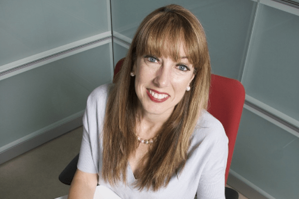 woman in chair in corner looking up and smiling