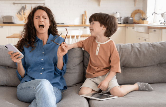 Mom and son on the couch, Mom is screaming and son is smiling