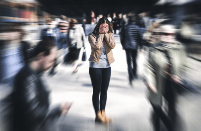 Woman in a blurry crowd looking like she is panicked