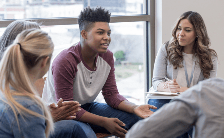 teens in a circle having a classroom meeting