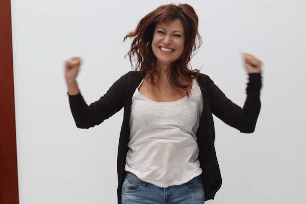 excited smiling woman jumps up and down with hands up