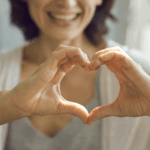 woman with hands in shape of a heart